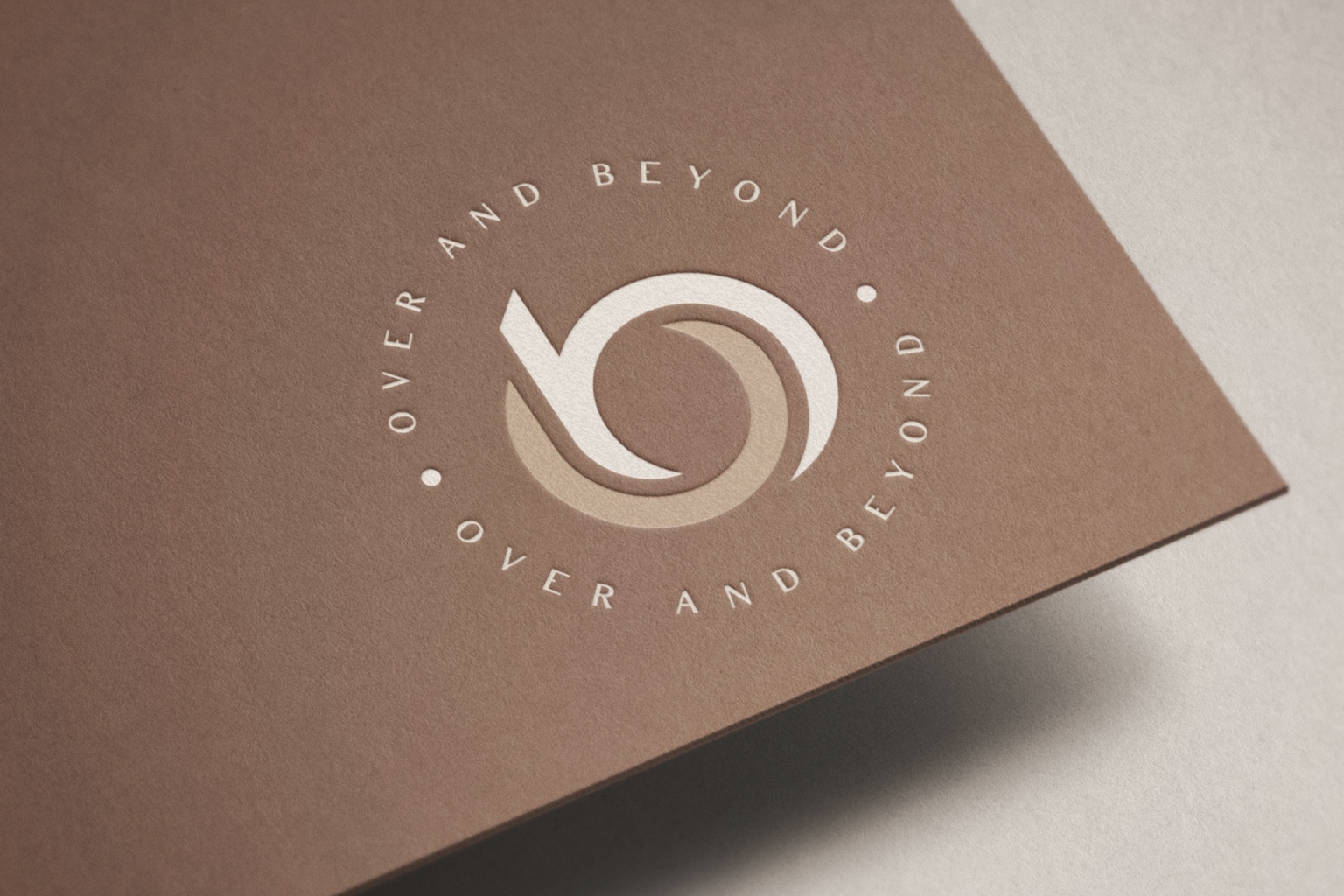 Over and Beyond monogram embossed on a warm cocoa card